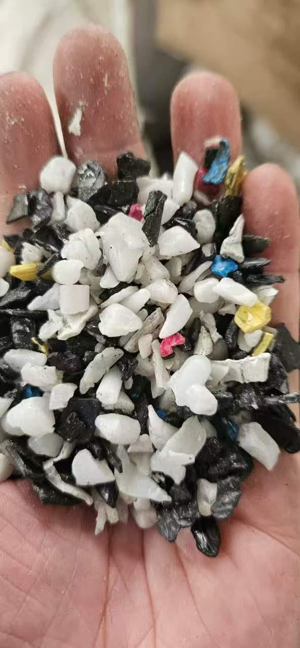 POM acetal regrind mixed white and colour flakes in hand